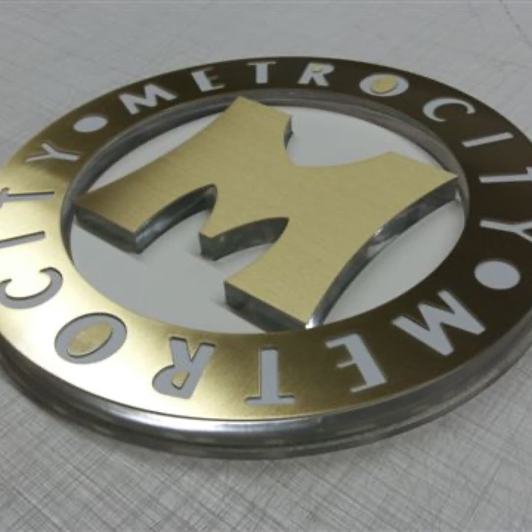 Logo in plexiglass e metallo con finitura dorata — realizzazione Gico Insegne